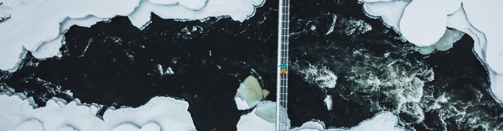 Man lying down over on a bridge over melted glacier