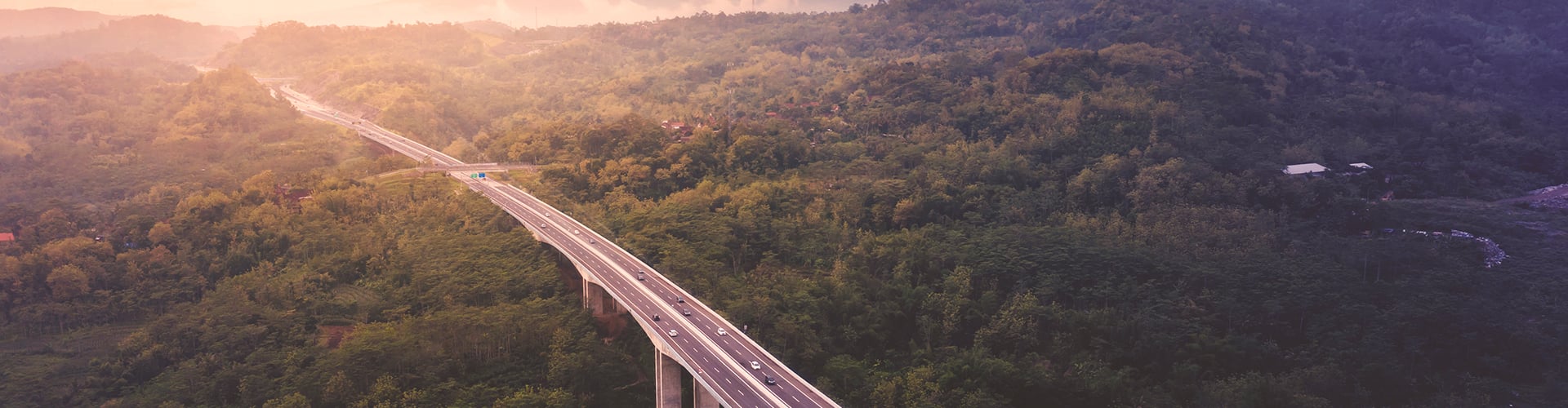 Motorway bridge running through green hills