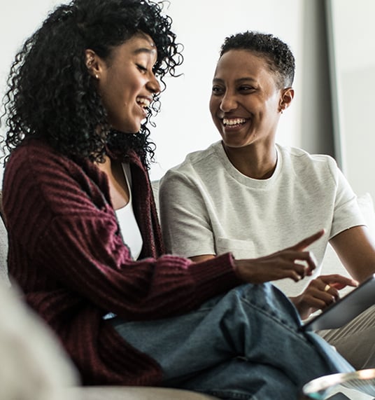 Two young people laughing and talking to each other