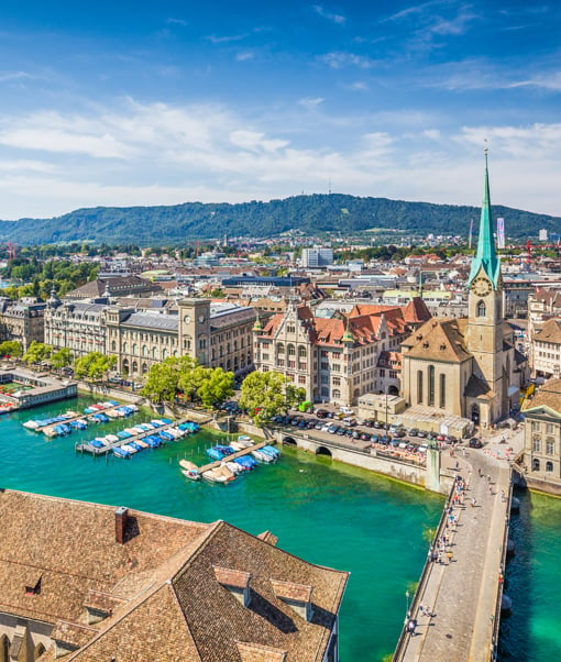 Waterfront Swiss town buildings with mountains behind