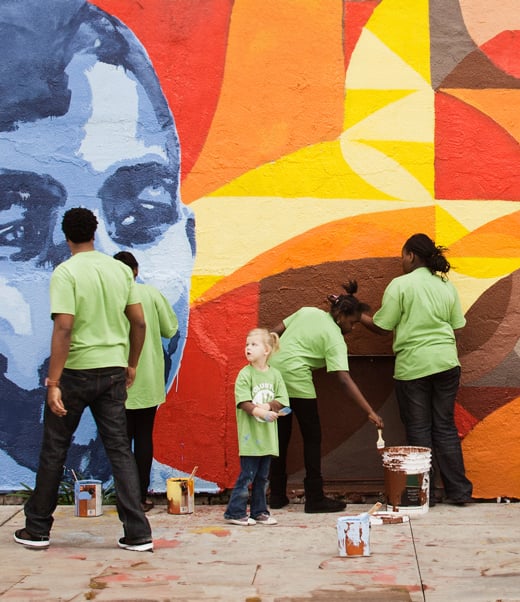 People painting mural on wall