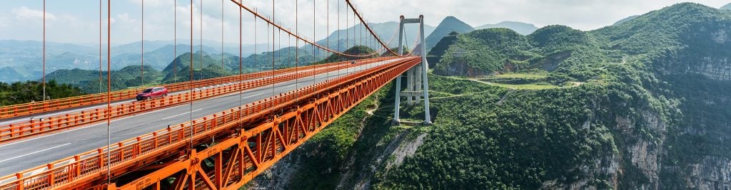 Dimu bridge over mountains covered by green forest in Guizhou China