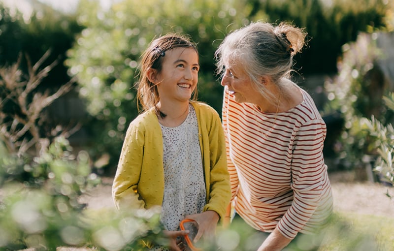 Girl and older woman sitting in grassland