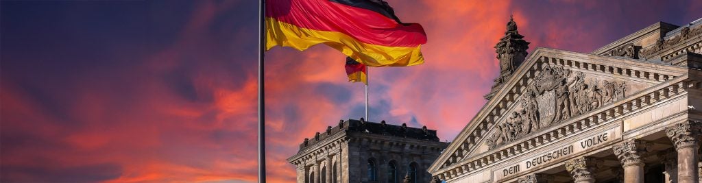 Deutscher Bundestag - Reichstag building and German flag at sunset (German parliament building) - Berlin Germany